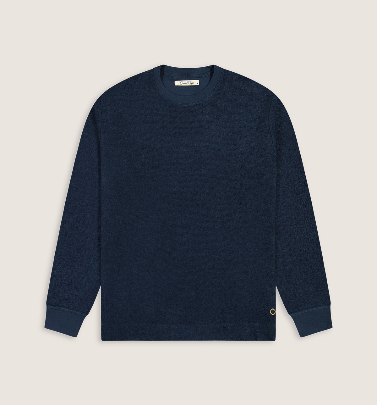 A dark navy blue crewneck sweatshirt with ribbed cuffs and hem, laid flat against a light beige background. A small gold embroidered 'C' logo is visible on the lower left cuff.