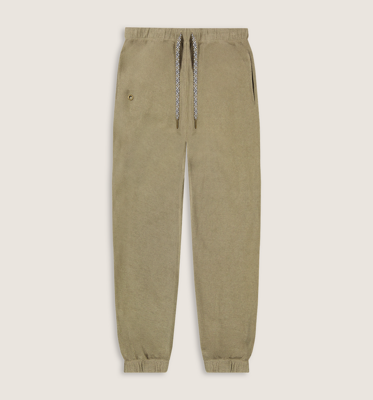 A pair of relaxed-fit jogger pants in a muted khaki-beige color, featuring a matching fabric waistband, elastic cuffs, and a decorative braided drawstring with a small gold button accent.